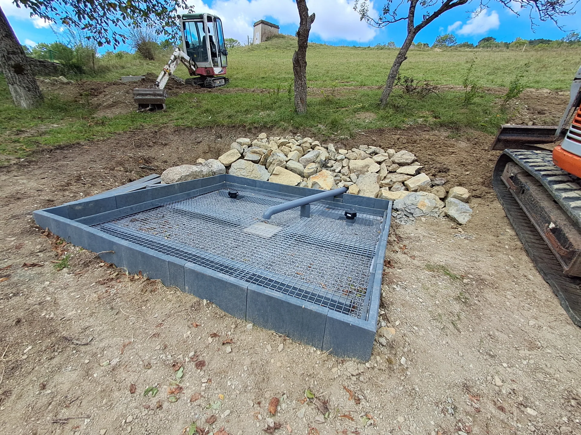 Bassin filtrant horizontal d'une phytostation en cours d'installation, mini-pelle Martin Hervé Terrassement en arrière-plan